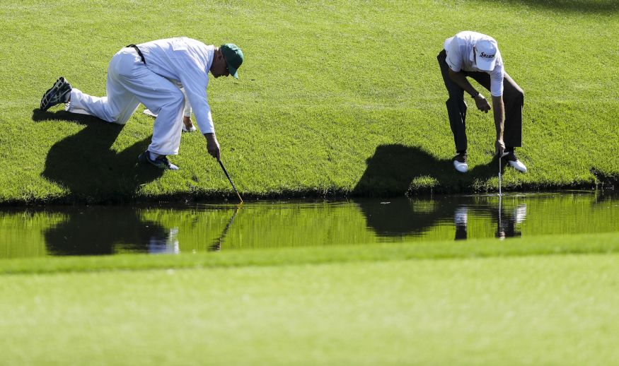 AUGUSTA, GA - APRIL 04:  Larry Mize and his caddie Chris Frame look in the water for a ball on the 12th hole during a practice round prior to the start of the 2017 Masters Tournament at Augusta National Golf Club on April 4, 2017 in Augusta, Georgia.  (Photo by David Cannon/Getty Images)